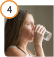 Woman drinking water after taking CREON® (pancrelipase) Delayed Release Capsules.