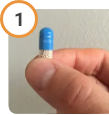 Hand holding CREON® (pancrelipase) Delayed Release Capsule upright.