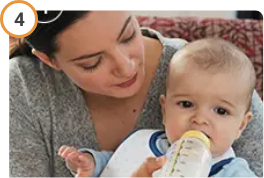 Mother feeding her baby a bottle after giving CREON® (pancrelipase) Delayed Release Capsules.