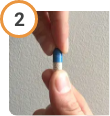 Hand twisting off the top of CREON® (pancrelipase) Delayed Release Capsules.