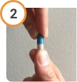 Hand twisting off the top of CREON® (pancrelipase) Delayed Release Capsules.